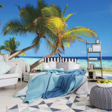 Eine Fototapete mit Palmen an einem sonnigen Strand mit Meer, sichtbar in einem Schlafzimmer.