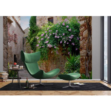 Eine Fototapete eines Terrassengartens in Peratallada in einem Wohnzimmer mit Vliestapete.