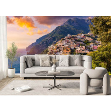 Ein Wohnzimmer mit einer Fototapete, auf der Positano bei Sonnenuntergang zu sehen ist.