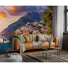 Fototapete Positano bei Sonnenuntergang mit Blick auf das Meer und das Bergdorf in einem Wohnzimmer.