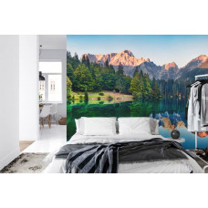 Eine Fototapete mit einem spiegelnden See zwischen Bergen, abgebildet in einem Schlafzimmer.