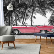 Fototapete eines roten Autos in Kuba mit Palmen und dem Meer im Hintergrund, perfekt für das Wohnzimmer.