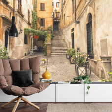 Eine Fototapete mit einer charmanten italienischen Gasse in Rom, abgebildet in einem Wohnzimmer.