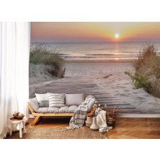 Fotobehang Romantische Zonsondergang aan het Strand in de woonkamer, met een prachtig uitzicht over een houten pad dat naar de zee leidt, terwijl de zon het zand in gouden kleuren kleurt.