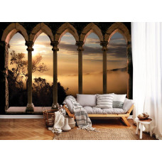 Fototapete im Wohnzimmer mit dreidimensionaler Darstellung antiker Säulen und mediterranem Hintergrund.