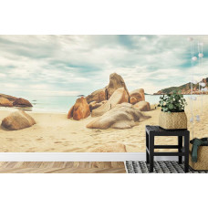 Eine Fototapete mit einer malerischen Meer- und Strandlandschaft mit Felsen, geeignet für ein Schlafzimmer.