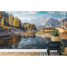 Eine Fototapete mit einem friedlichen See mit Wäldern und Bergen, abgebildet in einem Büro.