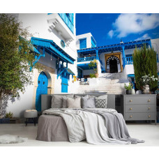 Eine Fototapete, die eine malerische Straße in Tunesien mit blauen Häusern zeigt, gedruckt auf Vliestapete und Airtex, geeignet für ein Schlafzimmer.