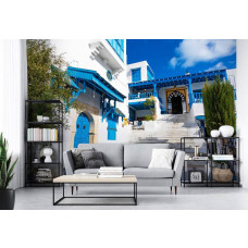 Eine Fototapete, die eine malerische Straße in Tunesien zeigt, umgeben von blauen Häusern, perfekt für ein Wohnzimmer.