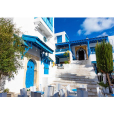 Fototapete einer Straße in Tunesien, mit blauen Häusern und mediterraner Atmosphäre.