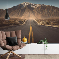 Eine Fototapete mit einem 3D-Bild einer Straße, die in die Berge führt, perfekt für ein Wohnzimmer.