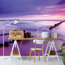 Fototapete, die einen Strand und einen violetten Sonnenuntergang in einem Büro mit Blick aufs Meer zeigt.