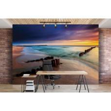 Eine Fototapete, die einen Strand bei Sonnenuntergang mit einem farbenfrohen Himmel und Wolken in einem Büroraum zeigt.