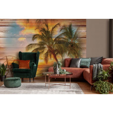 Eine Fototapete mit einem tropischen Sonnenuntergang, Meer und Dünen mit Palmen in einem Wohnzimmer.