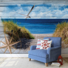 Eine Fototapete von einer natürlichen Strandlandschaft mit Dünen und Meer in einem Schlafzimmer.