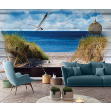 Eine Fototapete von einer Küstenlandschaft mit Meer und Dünen auf einem Holzplanken-Hintergrund in einem Wohnzimmer.