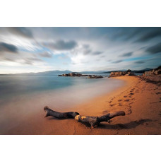 Fototapete mit einer Zeitrafferaufnahme eines Strandes, wo Ozeanwellen den Sand in einer ruhigen Umgebung verschlingen.