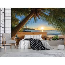 Ein modernes Schlafzimmer mit einer Fototapete von einer tropischen Szenerie mit einer Palme, einem Strand, einem warmen Sonnenuntergang und dem stillen Meer.