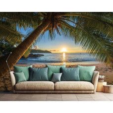 Tropische Fototapete mit einer wunderschönen Palme in einem paradiesischen Strandsetting, mit einem bunten Sonnenuntergang und beruhigendem Meer, platziert im Wohnzimmer.