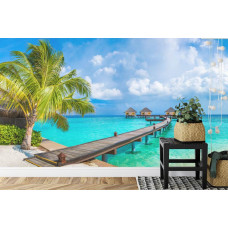 Eine Fototapete mit einer tropischen Strandszene mit Palmen und Meer in einem Schlafzimmer.