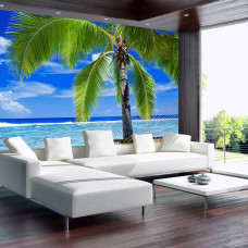 Eine Fototapete mit einem tropischen Urlaub Bild einer Palme und Strand mit Meer und Hängematte, sichtbar in einem Wohnzimmer.