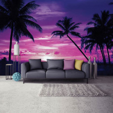 Eine Fototapete mit einem tropischen Sonnenuntergang am Meer mit Palmen, sichtbar in einem Wohnzimmer.