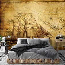 Eine Fototapete mit einem Vintage-Schiff auf einem Meer mit einer alten Landkarte, passend für ein klassisches Hotelzimmer.