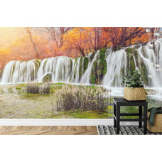 Eine natürliche Fototapete mit einem Wasserfall in einer bewaldeten Herbstlandschaft, ideal für eine Küche.