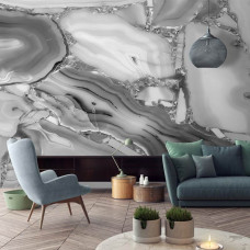 Eine stilvolle Vliestapete mit einer Marmoroptik in Weiß und Grau, ideal für ein Wohnzimmer.