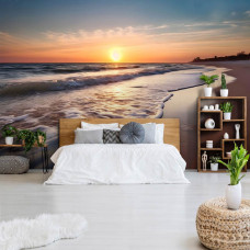 Eine Fototapete von Meer mit Sonnenuntergang und Strand im Schlafzimmer.