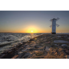 Meer und Windmühle bei Sonnenuntergang, dargestellt auf einer Fototapete mit Leuchtturm und Felsen.