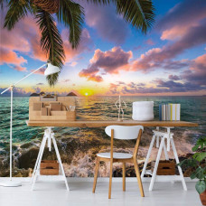 Fototapete mit Meerblick bei Sonnenuntergang, Palmenblätter im Lichtspiel der Sonne, ideal für das Wohnzimmer.