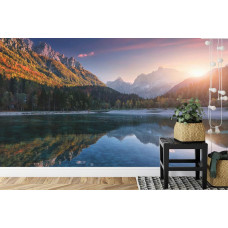 Eine Fototapete, die einen Sonnenuntergang über einem Bergsee und Bergen zeigt, angezeigt in einem Büro.