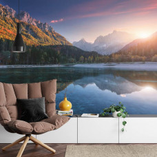 Eine Fototapete, die einen Sonnenuntergang über einem Bergsee zeigt, angezeigt in einem Wohnzimmer.