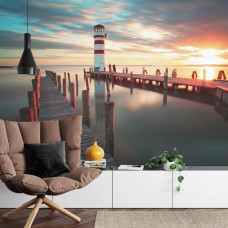 Eine Fototapete mit einem heiteren Sonnenuntergang an einem Leuchtturm und ruhigem Meer, geeignet für ein Wohnzimmer.