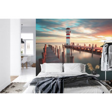 Eine Fototapete mit einem malerischen Leuchtturm am Meer unter einem farbenfrohen Himmel, perfekt für ein Schlafzimmer.
