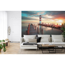 Eine Fototapete mit einem Leuchtturm, der bei einem warmen Sonnenuntergang leuchtet, ideal für ein Wohnzimmer.