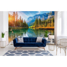 Ein Wohnzimmer mit einer Fototapete von einem Sonnenuntergang am Hintersee, mit einem malerischen Bergsee, der die warmen Abendfarben widerspiegelt, umgeben von wunderschönen hohen Bergen.