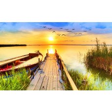 Fototapete von einem Sonnenuntergang über einem Pier, der über einen See hinausragt, umgeben von einer friedlichen Naturlandschaft.