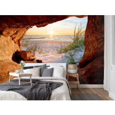 Eine Fototapete von einem Sonnenuntergang über dem Meer im Vliesbehangstil für ein Schlafzimmer.