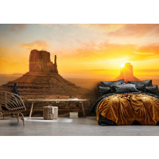 Fototapete eines dramatischen Sonnenuntergangs in der Wüste von Arizona, mit großen Felsen und tiefen Schatten, für ein ruhiges Schlafzimmer.