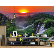 Eine Fototapete mit einem Sonnenuntergang in den Bergen mit Wasserfällen und Natur, zu sehen im Büro.