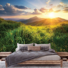 Eine Fototapete mit einem Sonnenuntergang über den Bergen, ideal für ein Schlafzimmer, wobei die Natur im Hintergrund mit sanften Farben die beruhigende Wirkung verstärkt.