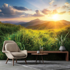 Eine Fototapete mit einer weiten Berglandschaft und einem Sonnenuntergang in der Ferne, gesehen aus einem gemütlichen Wohnzimmer.