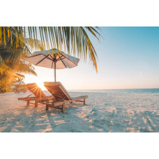 Fototapete eines tropischen Strandes bei Sonnenuntergang, mit Strandliegen mit Blick auf das ruhige Meer.