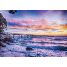 Sonnenuntergang über dem Meer mit einem Pier in der Ferne, festgehalten auf einer Fototapete.