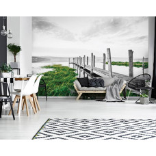 Eine Fototapete von einem Steg am See in einer Landschaft, die im Wohnzimmer zu sehen ist.