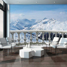 Eine Fototapete von einer Terrasse mit Blick auf schneebedeckte Berge, die eine ruhige und beeindruckende Atmosphäre schafft.