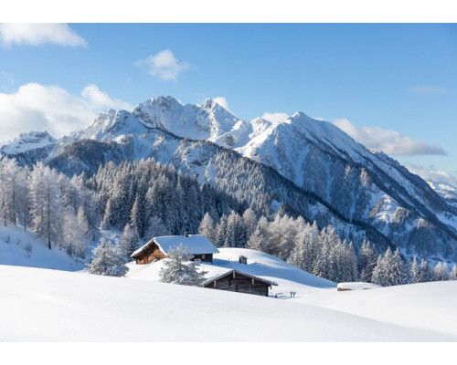 Fototapete einer verschneiten Berglandschaft, in der sich die Berge aus einer ruhigen, weißen Umgebung erheben.