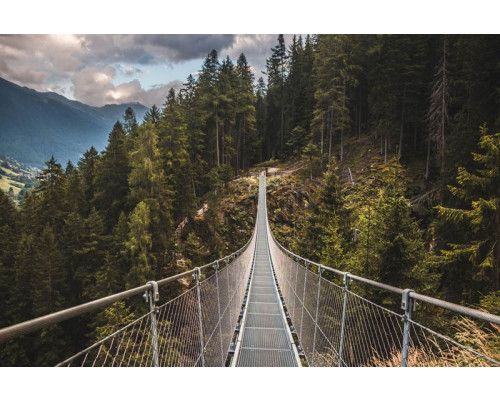 Die Hängebrücke in den Dolomiten in Italien, mit Bergen im Hintergrund, abgebildet auf einer beeindruckenden Fototapete.